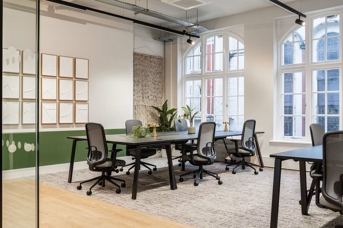 Arched windows, exposed brick detailing and touches of greenery give the desk space a distinctive sense of character.