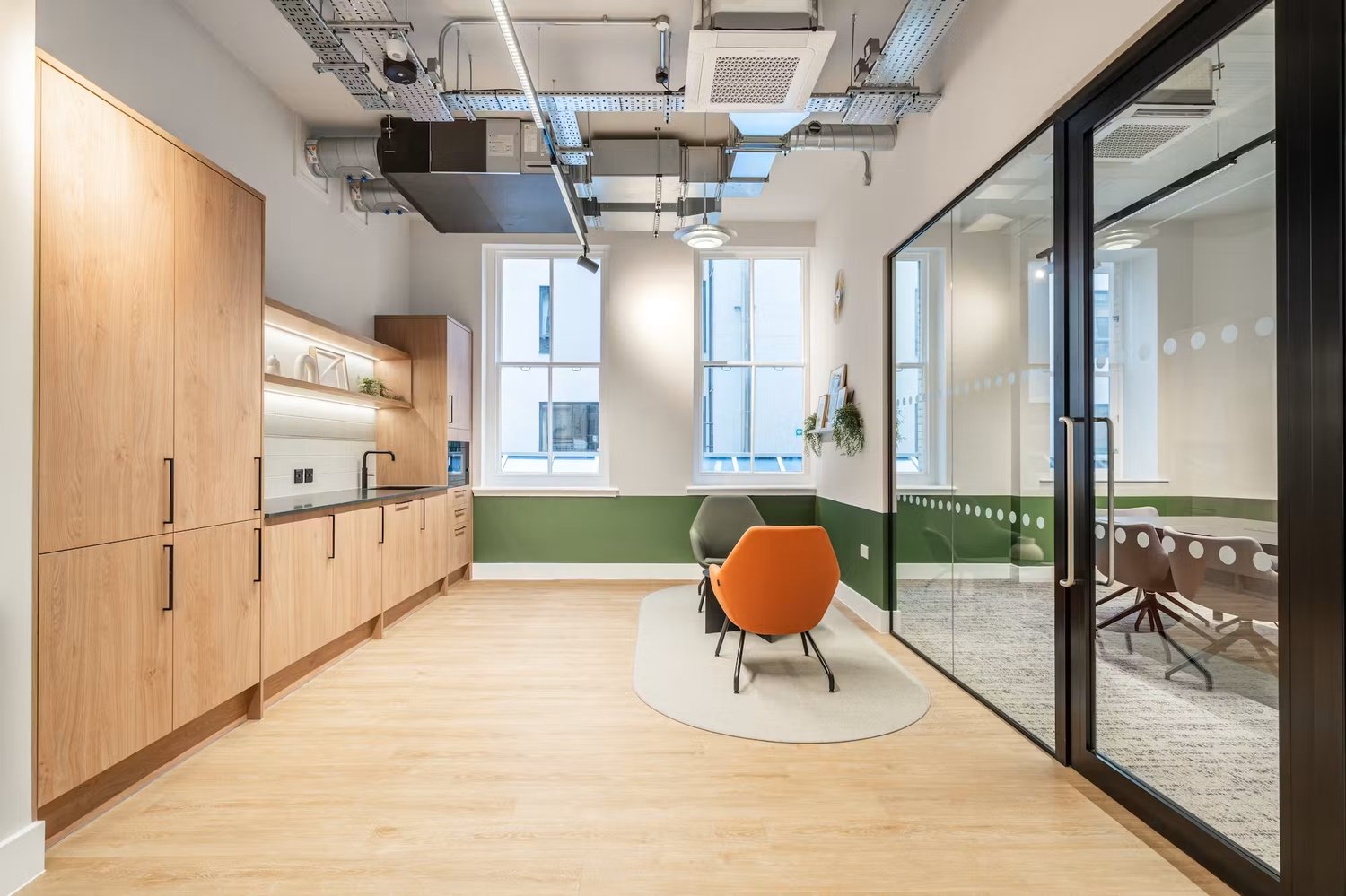 Warm wood cabinetry and soft seating bring a relaxed feel to the kitchen and breakout area.