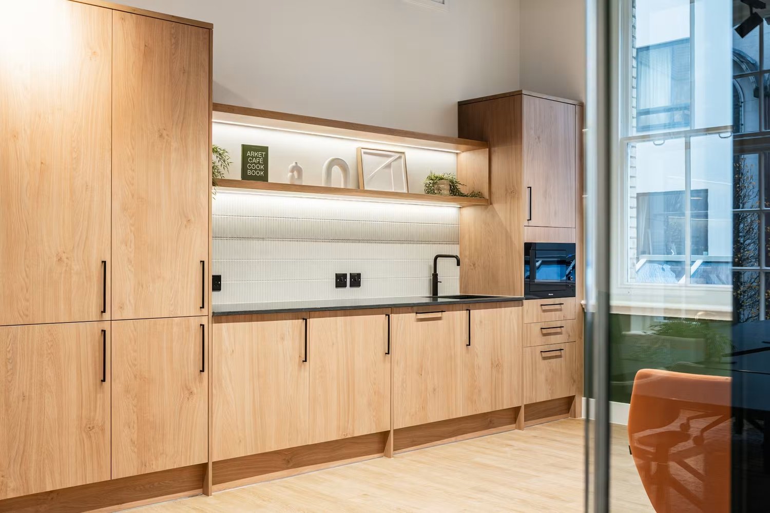 Generous storage, integrated appliances and illuminated shelving make the contemporary kitchen ready for everyday use.