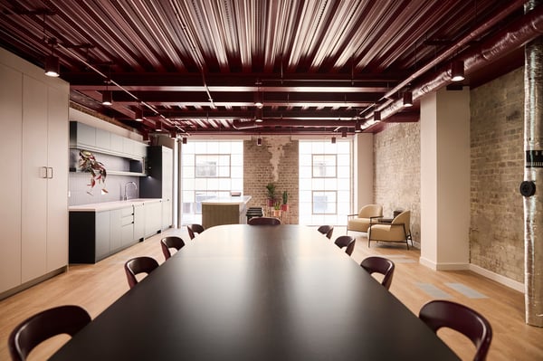 A private kitchenette and large communal table create a natural hub.