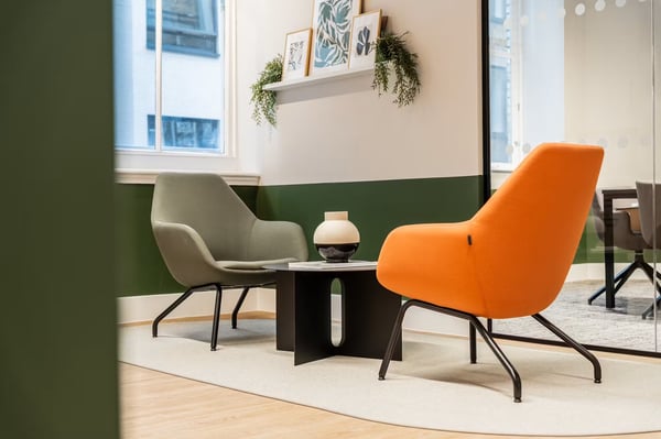 Colourful lounge chairs and botanical details create a welcoming corner for informal conversations or a break from the desk.