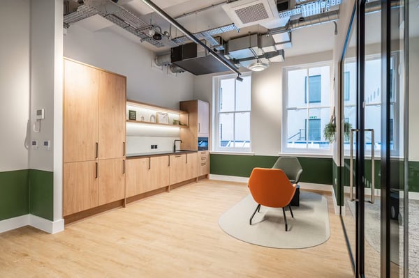 The kitchen and lounge corner sit beside the meeting room, with glazed partitions maintaining a bright, open feel.