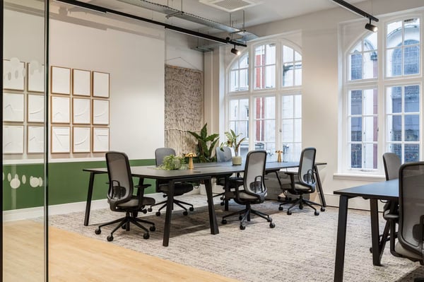 Arched windows, exposed brick detailing and touches of greenery give the desk space a distinctive sense of character.